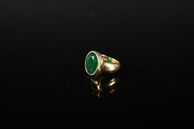 une bague en or avec une pierre verte au centre