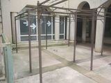 a metal structure with arrows on it in front of a building