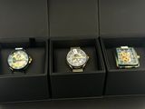 trois montres présentées dans un coffret noir dans une vitrine de magasin
