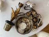 une table blanche sur laquelle est posé un bol contenant des objets en argent et en or