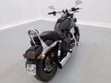 a black motorcycle that is parked in a white room