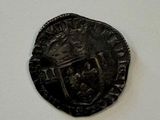 an old coin with a coat of arms on it on a white surface