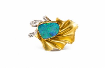un gros plan d'une bague en or sertie d'une opale bleue et de diamants