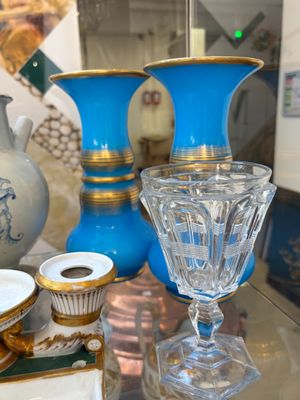 une table en verre sur laquelle sont disposés des vases bleus et d'autres objets décoratifs