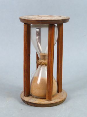 une image représentant un sablier rempli de sable posé sur une table
