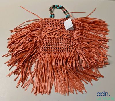 un sac à main orange dont la poignée est ornée de franges