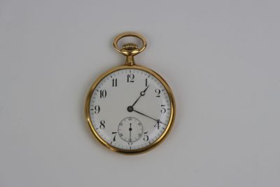 une montre de poche en or avec un cadran blanc sur une surface blanche