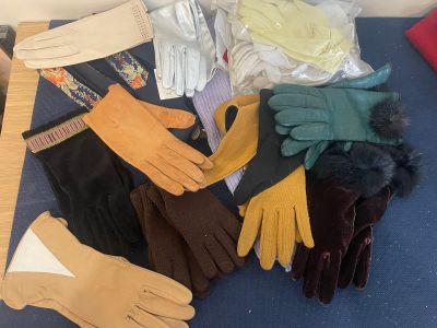 several pairs of gloves and gloves sitting on a blue surface