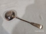 une cuillère en argent avec un manche de cuillère sur une surface blanche
