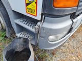 a trash can sitting next to a truck with a sign on it