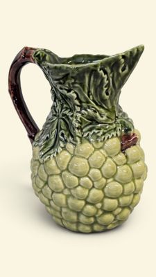 une cruche verte et marron ornée d'un motif de feuilles