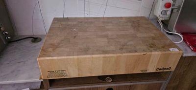 a wooden cutting board on the counter in the kitchen