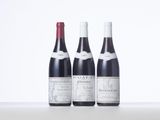 three bottles of wine are lined up on a table