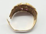a close up of a gold ring with a pink stone in the middle