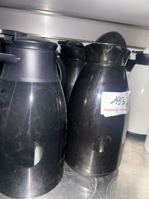 three black vases sitting on a counter in a kitchen