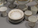 a lot of white and gold china on a table