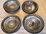 quatre assiettes marron et blanches posées sur une table