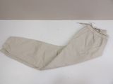 beige pants on a white table with a tag on it