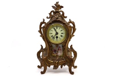 une horloge posée sur un support sur une surface blanche