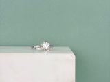 une bague en diamant posée sur un bloc de marbre blanc