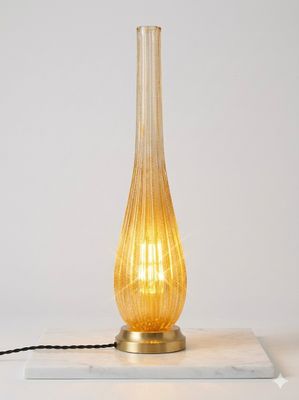 a glass lamp that is sitting on a marble block