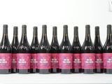 six bouteilles de vin rouge sont alignées sur une table