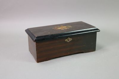 a small wooden box with a gold decoration on it
