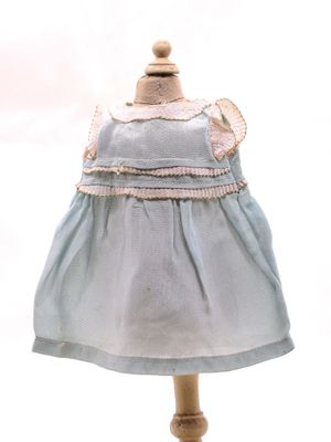 robe bleue posée sur un socle de mannequin, sur fond blanc