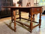 a wooden table with a drawer on it in a room