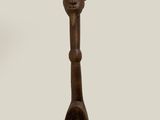 a wooden spoon with a face on it and a spoon in the shape of a spoon