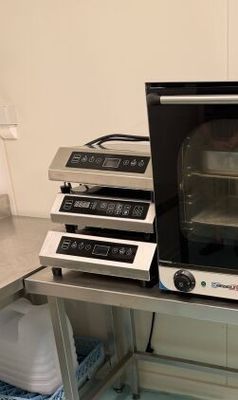 un four grille-pain posé sur une table, à côté d'autres fours