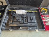 une caisse d'outils avec des outils à l'intérieur, posée sur le sol
