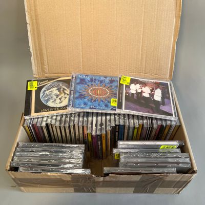 une boîte en carton remplie de CD, avec des CD à l'intérieur