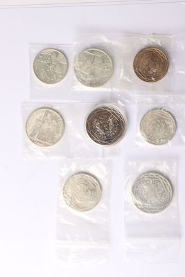 six different coins in a plastic bag on a white surface