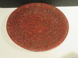 a red plate with a design on it on a white surface