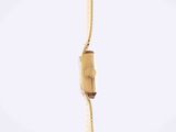 a gold watch hanging from a rope on a white background