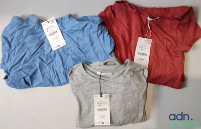 trois t-shirts avec leurs étiquettes de prix, posés sur une table