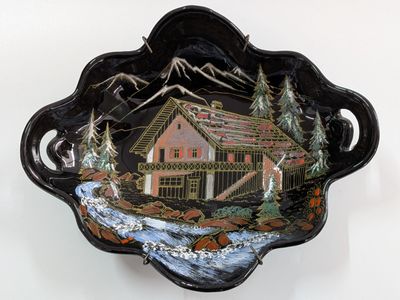 a black bowl with a picture of a cabin on it