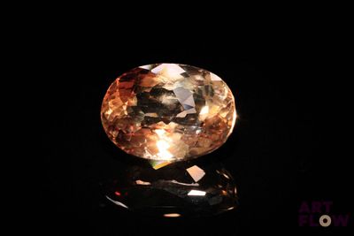 a close up view of a yellow diamond on a black surface