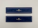 a pair of blue pencils sitting on top of a white surface