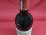 a bottle of wine that is sitting on a red cloth