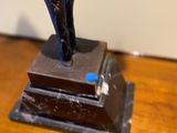 a statue of a man on a pedestal on a wooden table