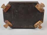 an old black suitcase with wooden handles on a white surface