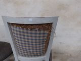 a chair that has hay in the back of it