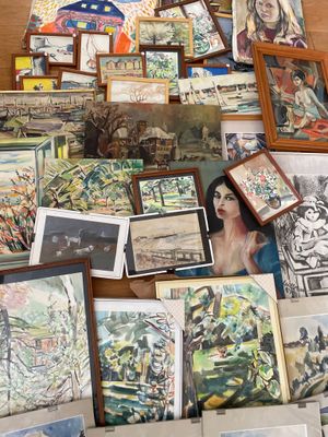 il y a beaucoup de tableaux posés par terre dans cette pièce