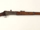un vieux fusil avec un canon en bois et une poignée en bois