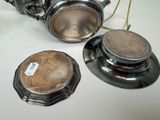 two silver teapots sitting on a table next to each other