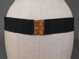 a close up of a mannequin torso with a black belt and gold buckle