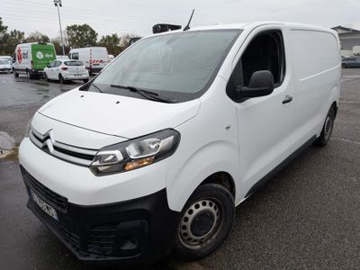 la camionnette blanche est garée dans un parking avec d'autres véhicules