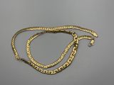 une paire de bracelets en or posés sur une surface grise